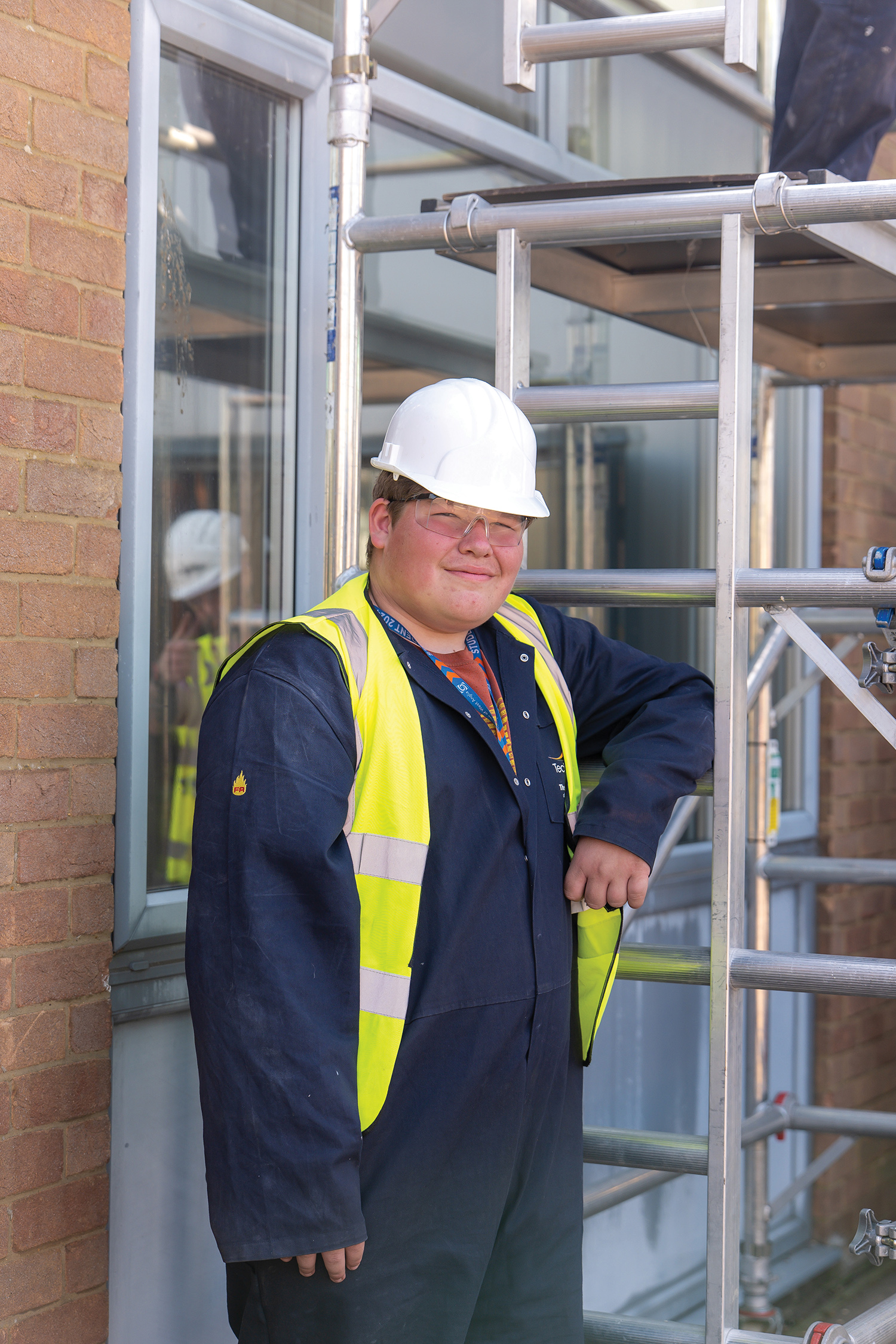 Male student leaning against scaffolding 